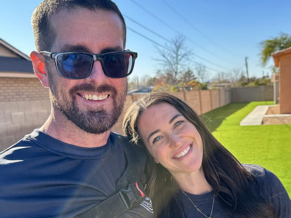 Stacie Barber is smiling with her husband outdoors