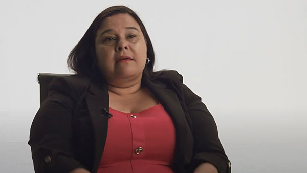 Captura de pantalla de un video de Marissa Ulloa, sobreviviente de ataque o derrame cerebral, sentada en una silla frente a un fondo neutro