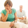 Senior woman upset while concerned husband looks on