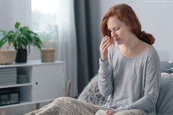 a woman sitting on a sofa with a look of distress